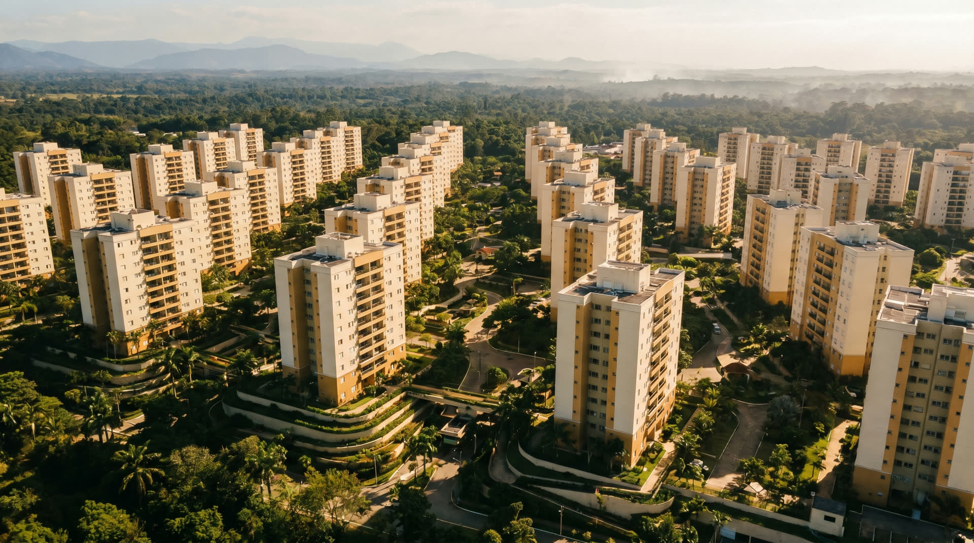 Vista aerea de um grande complexo residencial entre arvores na luz da tarde