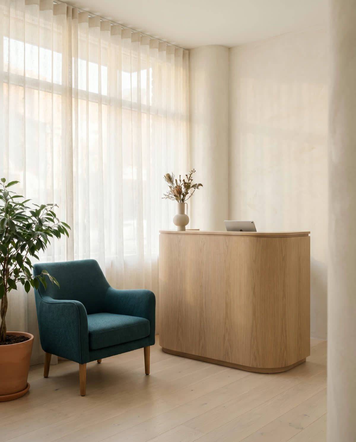 Recepção da clínica com poltrona azul-petróleo e cortinas de linho