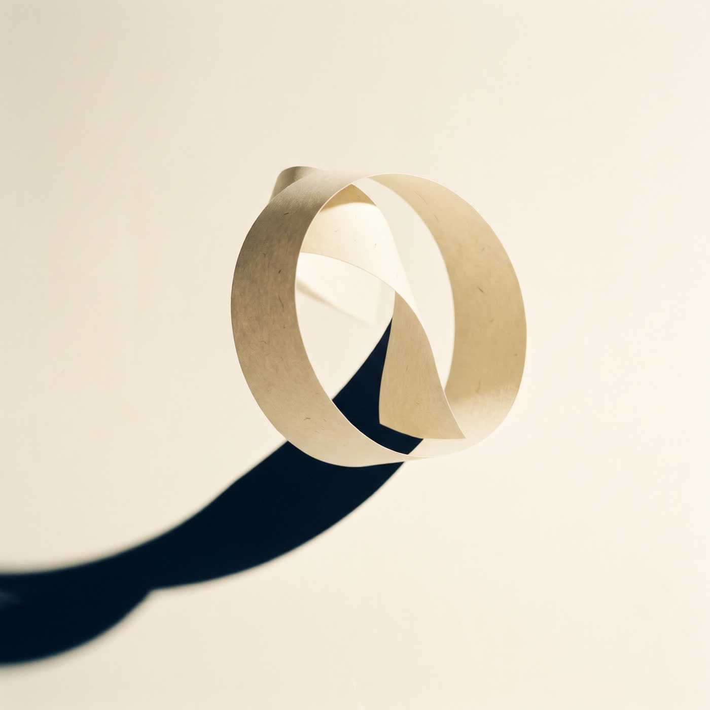 Escultura de papel creme em fita contínua sobre fundo claro