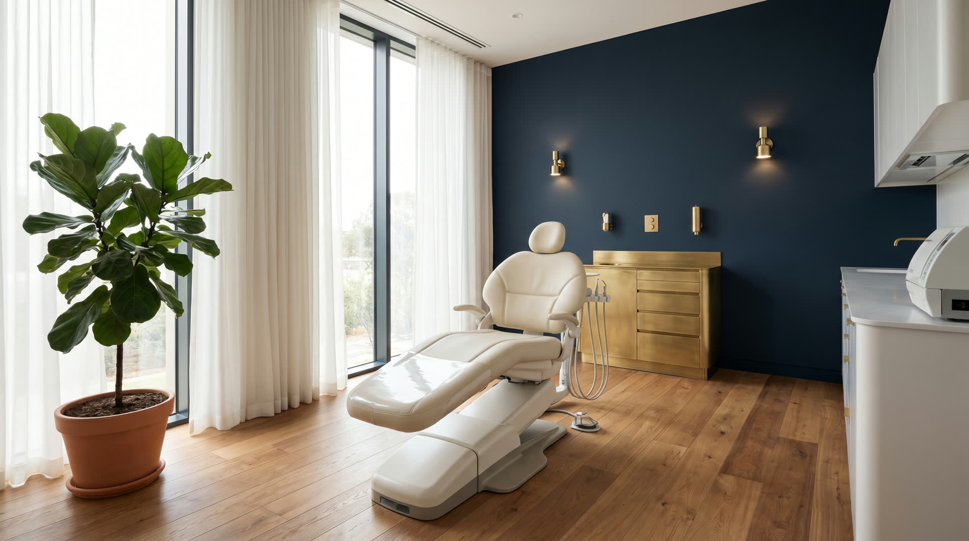 Sala de atendimento odontológico com cadeira clara, parede azul profundo e detalhes em latão